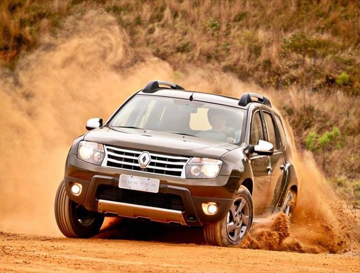 SUV driving through dusty off-road terrain